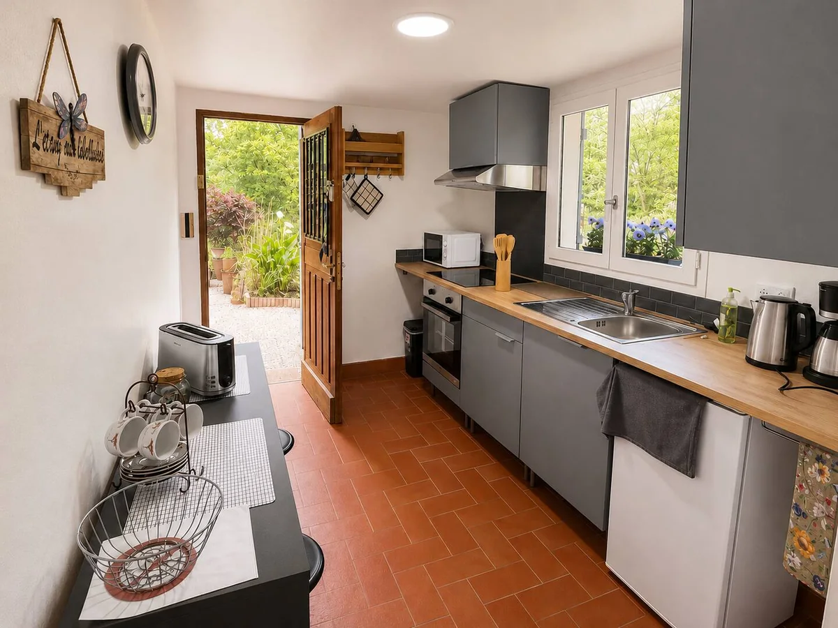 La cuisine équipée du logement, porte ouverte sur le jardin
