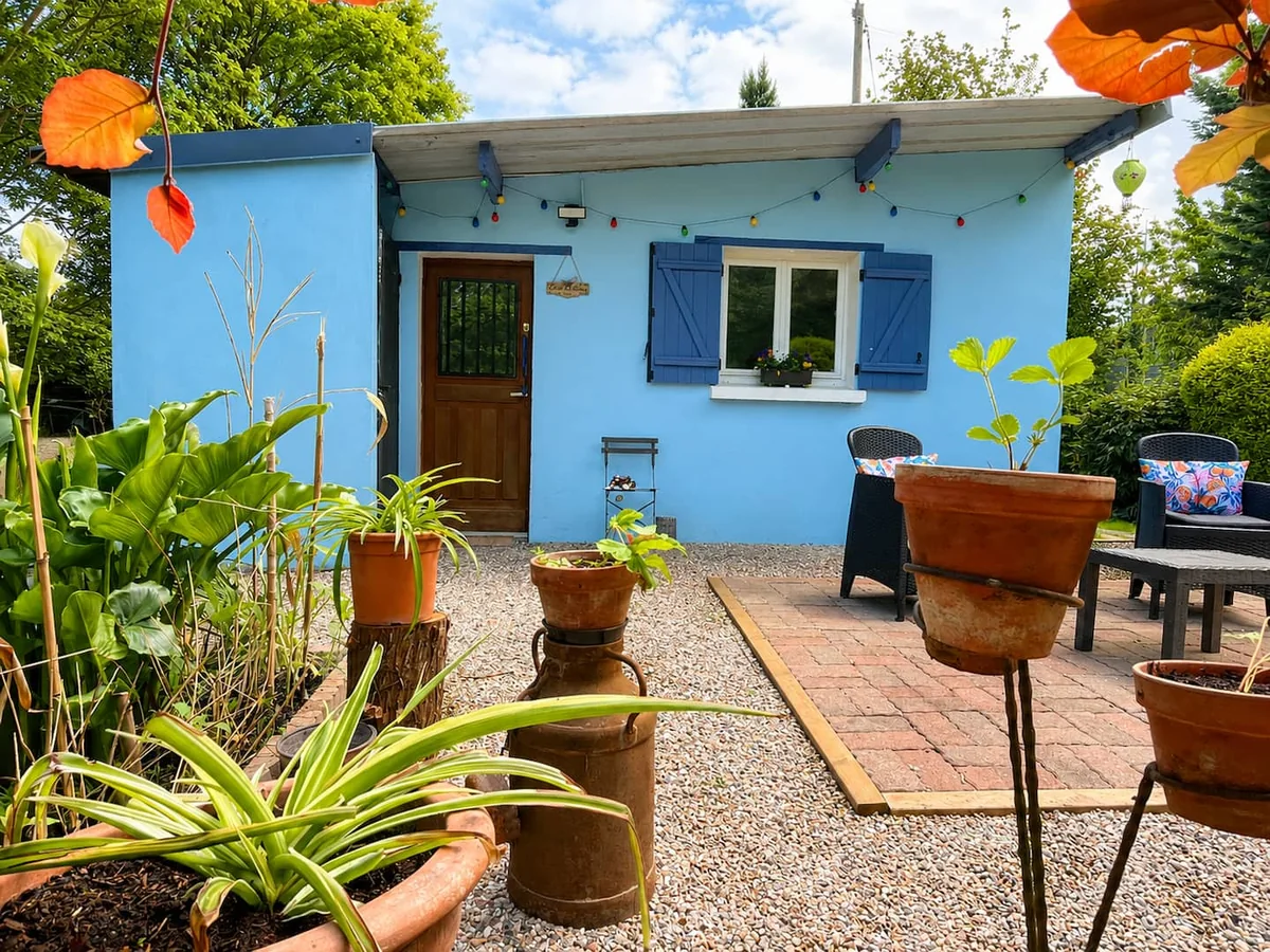 La maison bleue de L’Étang aux Libellules, sa porte en bois et sa cour plantée